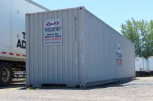 Dart Portable Storage 40-foot container placed on gravel lot beside trailers
