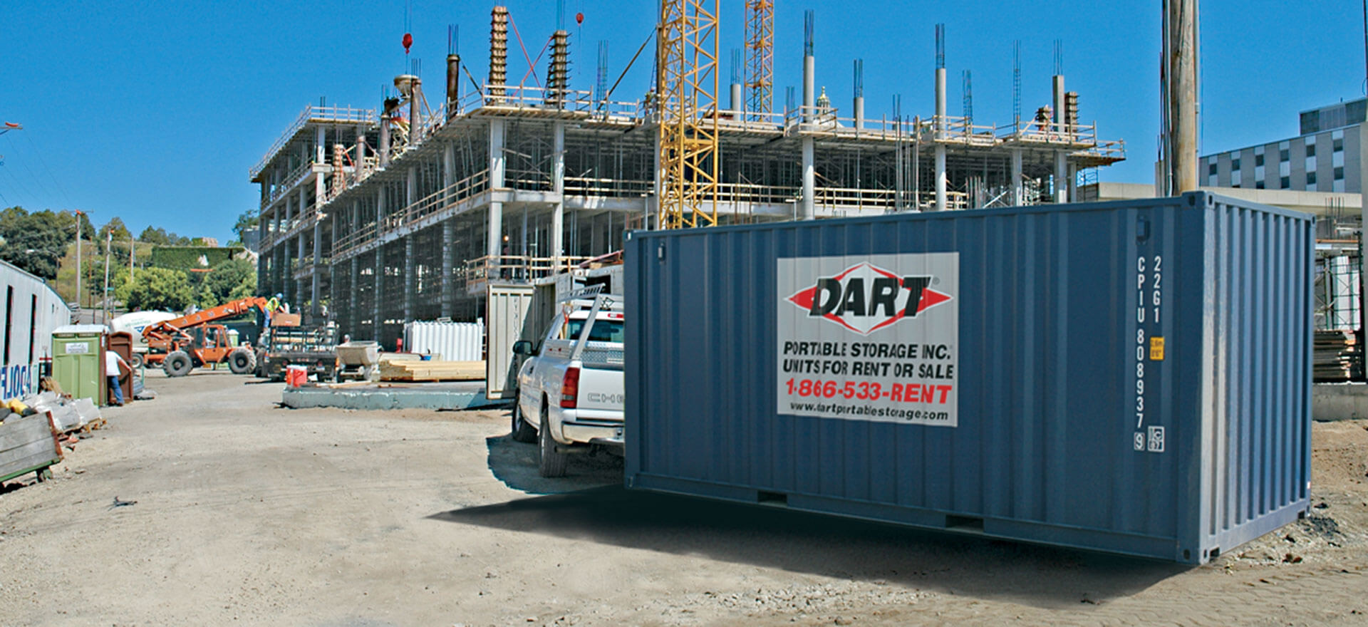 Blue Dart Portable Storage container at busy construction site with crane