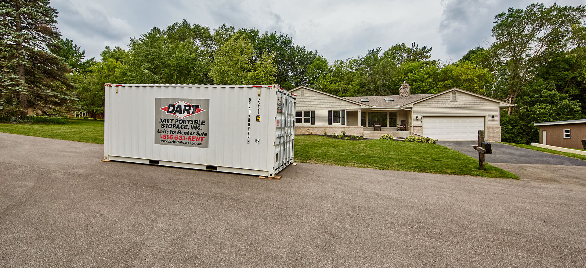 Dart Portable Storage container placed in residential driveway in front of house